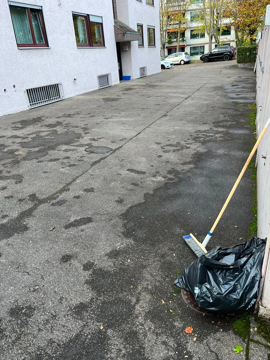 Hinterhof beim Kehreinsatz mit Besen und Laubsack – echtes Einsatzfoto
