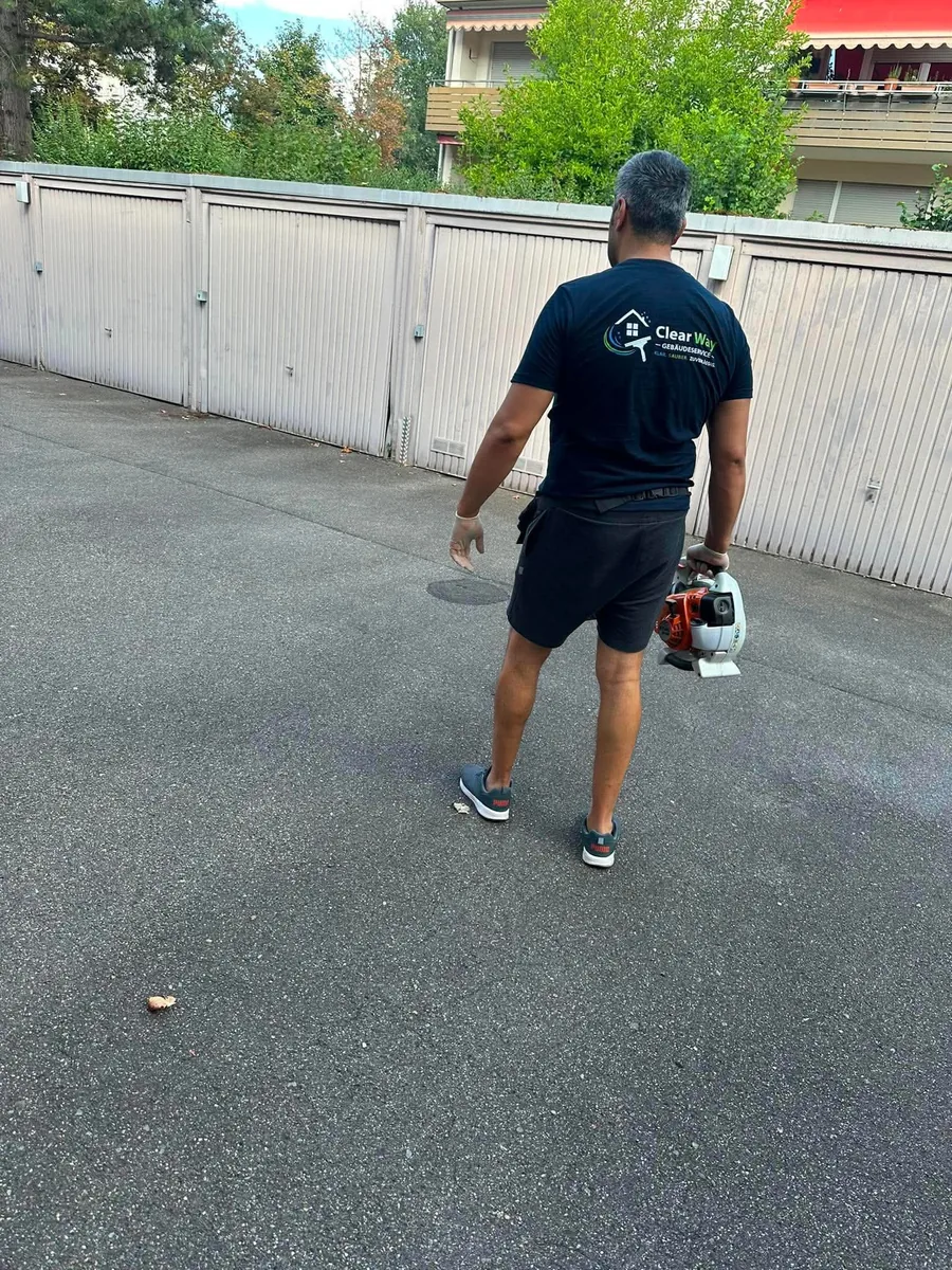ClearWay-Mitarbeiter beim Laubeinsatz auf dem Hof einer Wohnanlage