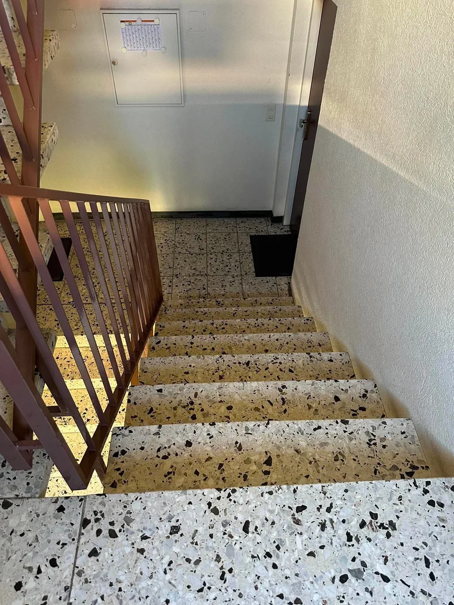 Eingangsbereich mit Fußmatte und Terrazzoboden am Fuß der Treppe – echtes Einsatzfoto