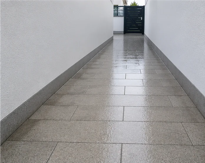Derselbe Durchgangsweg nach der Reinigung mit hellen Platten und sauberer Wand